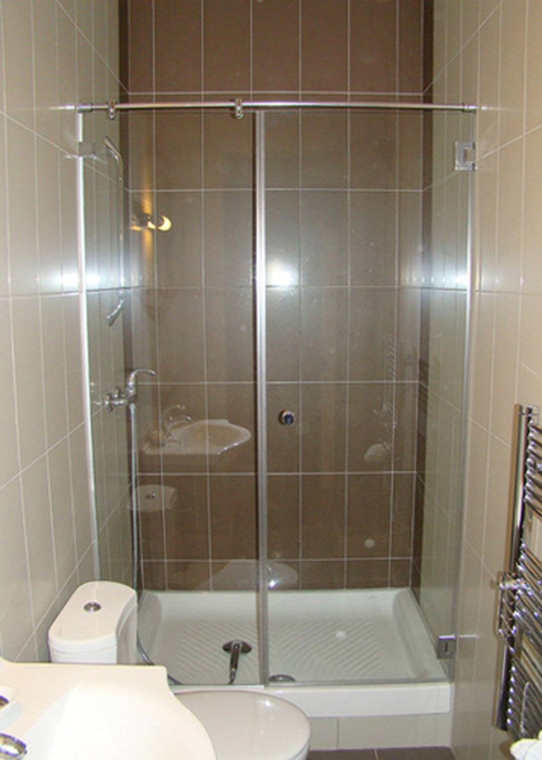 Маленькая ванная комната с душевой кабиной, перегородкой из стекла, стиральной машиной и туалетом: дизайн
 - 33 фото